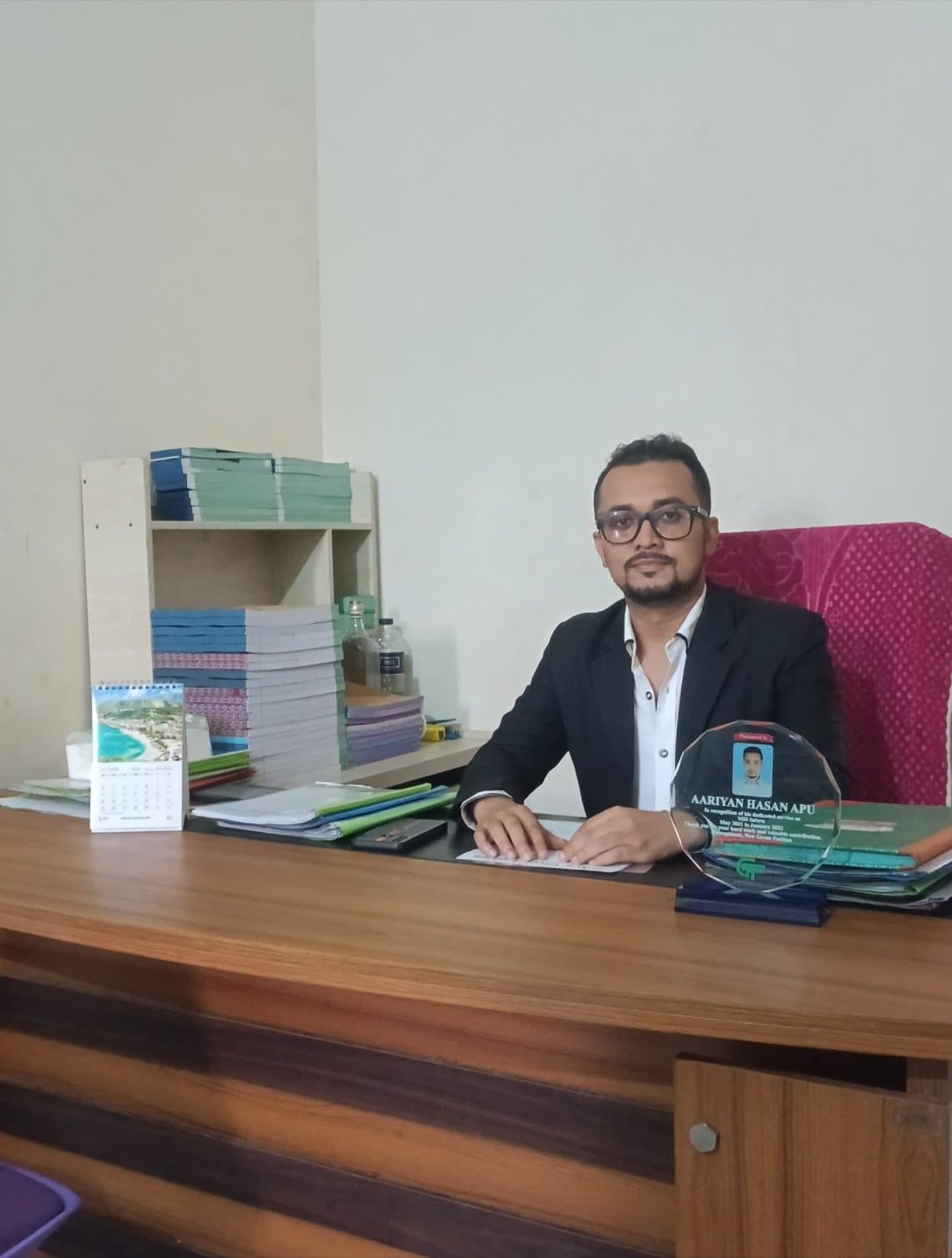 Aariyan Apu at the accounts desk of New Green Fashion in Ashulia, Dhaka, with the MIS internship recognition award